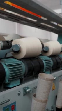 İplik üretimi. İplik yapma süreci. Dönen yapım. Tekstil fabrikası ekipmanı. Tekstil fabrikası. Fabrika makineleri makaraları ya da pamuklu ya da yün ipliklerle bobinleri geri sarıyor.