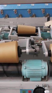 Dönen yapım. Tekstil fabrikası. İplik yapma süreci. İplik üretimi. Tekstil fabrikası ekipmanı. Fabrika makineleri makaraları ya da pamuklu ya da yün ipliklerle bobinleri geri sarıyor.