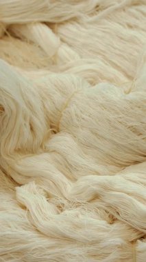 İplik üretimi. Tekstil fabrikası. Dönen yapım. İplik yapma süreci. Tekstil fabrikası ekipmanı. İplik. Yün ya da pamuk yumağı. yakın plan.