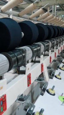 İplik üretimi. İplik yapma süreci. Dönen yapım. Tekstil fabrikası ekipmanı. Tekstil fabrikası. Fabrika makineleri makaraları ya da pamuklu ya da yün ipliklerle bobinleri geri sarıyor.