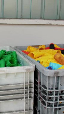 Büyük bir sepetin içinde delinmiş boyama tüpleri. Tekstil fabrikası ekipmanı. İplik üretimi. Tekstil fabrikası. Dönen yapım. İplik oluşturma süreci