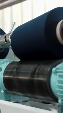İplik ipliklerinin yakın çekim makaraları. İplik üretimi. İplik yapma süreci. Dönen yapım. Tekstil fabrikası ekipmanı. Tekstil fabrikası. Fabrika makineleri makaraları ya da pamuklu ya da yün ipliklerle bobinleri geri sarıyor.
