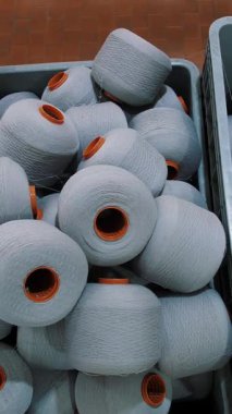 Bir sepetteki iplik maşaları. İplik üretimi. Tekstil fabrikası. Dönen yapım. İplik yapma süreci. Tekstil fabrikası ekipmanı.