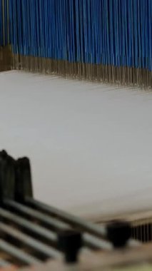 Dokuma tezgahı. Yakın plan. Bir tekstil fabrikasında endüstriyel dokuma tezgahı makinesi çalışıyor. Dokuma.