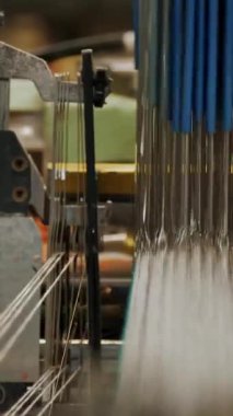 Tekstil fabrikası. Dokuma. Çalışan otomatikleştirilmiş dokuma makinelerinin yakın çekim görüntüleri. Tekstil fabrikası ekipmanı. Dokuma kumaşı endüstriyel bir makine tarafından serbest bırakılıyor..