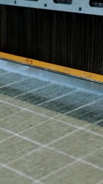 Tekstil fabrikası. Dokuma. Çalışan otomatikleştirilmiş dokuma makinelerinin yakın çekim görüntüleri. Tekstil fabrikası ekipmanı. Dokuma kumaşı endüstriyel bir makine tarafından serbest bırakılıyor..