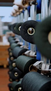 İplik makaraları. Yakın plan. Bir sürü iplik makarası olan raflar. Boyama için iplikleri hazırlama süreci, istenen rengin kumaşlarının üretimi için. otomatik çalışma süreci.