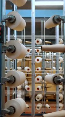 İplik makaraları. Tekstil endüstrisi. Dokuma fabrikası. Bir sürü iplik makarası olan raflar. Daha fazla kumaş üretimi için ipliklerin boyanıp kurutulması. Otomatik çalışma süreci. tekstil üretimi.