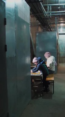 Ukrayna 'da savaş. Sığınak. Çocuklar bodrumda bir sığınakta saklanıyorlar, hava alarmı sırasında, roket ateşi. Çizim yapıyorlar. Rus istilası. Savaşı durdurun. Savaş Yok.