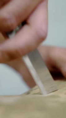 Dikiş dikiyorum Yakın plan. Terzi dikiş masasında kumaşı özel bir bıçakla, bez kesiciyle keser. Dikiş atölyesi. Haki, koyu yeşil kumaş. Kamuflaj kıyafetleri dikiyorum..