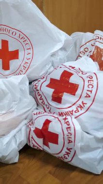 Kızıl Haç. Hayır kurumu. Gönüllü Depo. İnsani yardım paketleri, kırmızı haç amblemli karton kutular. Yoksul insanlar için sosyal bağışlar