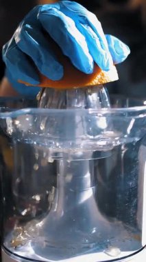 Turuncu taze. Meyve sıkacağı. Portakal suyu yapıyorum. Turunçgil suyu. Yakın plan. Eldivenli bir el portakaldan meyve suyu sıkıyor..