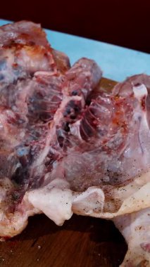 Korkak. Yemek pişirmek. Yakın plan. Şef taze çiğ tavuğu baharat ve tuz ile kesme tahtasına sürterek serpiyor. Şef pişirmek için tavuk pişirir.