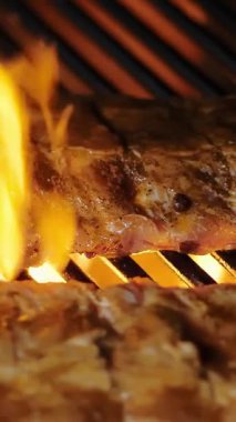 Izgara et. Yakın plan. Sulu domuz pirzolası ızgarada kızartılır. Lokanta mutfağında ızgara ızgara olur. Barbekü, barbekü, ızgara..