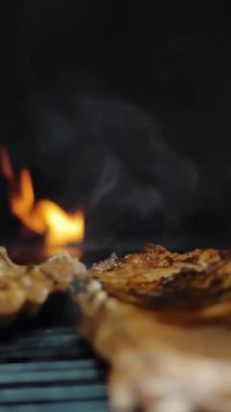 Izgara et. Yakın plan. Döndürme. Sulu domuz pirzolası ızgarada kızartılır. Lokanta mutfağında ızgara ızgara olur. Barbekü, barbekü, ızgara..