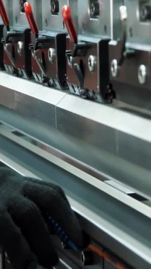 Metal bükme. Yakın plan. Fabrikadaki hidrolik bir makinede metal bükme levhası. Metal işleme makinesi. Metalurji endüstrisi.