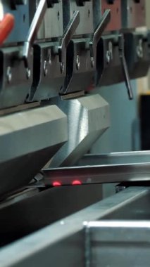 Metal bükme. Teknisyen fabrikadaki metal levhaları metal levha bükme makinesiyle büküyor. metalişleme makinesi.