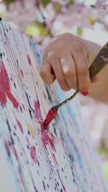 Beyaz elbiseli, sanatçı boya bir resim içinde çiçek açan çiçeklerin güzel kadın ressam portresi bahar elma bahçesi, o özel çizim tekniği kullanır. Palet boya tutar