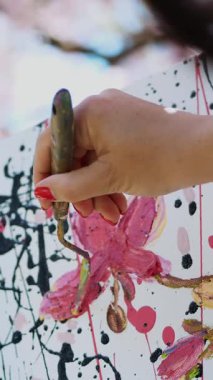 yakın çekim, el, ressam, ressam boyalar bir resim çiçek çiçek açan bahar elma bahçesi, o özel küçük spatula ile tuvale boya geçerlidir, palet boya tutar