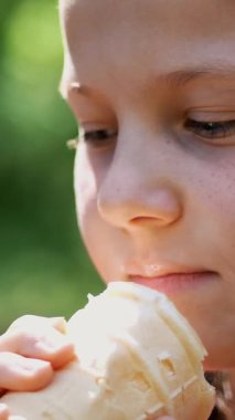 portre, sekiz yıllık, sarışın, beyaz dondurma bir gözleme kaba yeme çilli güzel kız diliyle yalıyor. Yaz