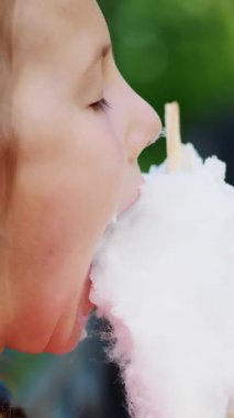 portre, sekiz yıllık, çiller ve çok renkli pigtails, sarışın güzel kız tatlı beyaz pamuklu, pamuk şeker, candyfloss yiyor. eğleniyor, yaz aylarında Şehir Parkı