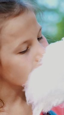 portre, sekiz yıllık, çiller ve çok renkli pigtails, sarışın güzel kız tatlı beyaz pamuklu, pamuk şeker, candyfloss yiyor. eğleniyor, yaz aylarında Şehir Parkı