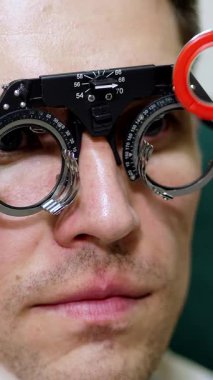 yüz yakın çekim, göz doktoru hasta adam optometrist deneme çerçeve, görsel kontrol cihaz ile incelenmesi. İmgelemde Oftamolojik klinik kontrol etmek için erkek hasta,