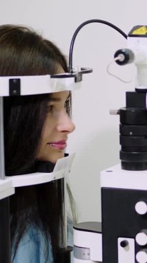 Kadın doktor optometrist, temassız tonometreye sahip göz doktoru hastanın görüşünü, göz kliniğinde veya optik mağazasında göz içi baskıyı, göz doktorunu ve göz doktorunu kontrol ediyor..