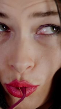 Kırmızı dudaklı esmer bir kadının portresi şık gözlük ve gözlük takan ve stüdyoda kameraya bakan. koyu gri arkaplan.