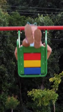 gülümseyen, mutlu sekiz yaşındaki kız salıncakta, açık havada, sallanan bir park, yaz, tatil sırasında sıcak gün