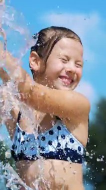 gülümseyen, mutlu sekiz yaşındaki kız sokak şehir Çeşme, açık havada, su sıçramalarına, eğleniyor park, yaz, tatil sırasında sıcak güneşli gün mayo.