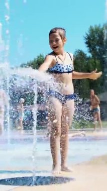 gülümseyen, mutlu sekiz yaşındaki kız sokak şehir Çeşme, açık havada, su sıçramalarına, eğleniyor park, yaz, tatil sırasında sıcak güneşli gün mayo.