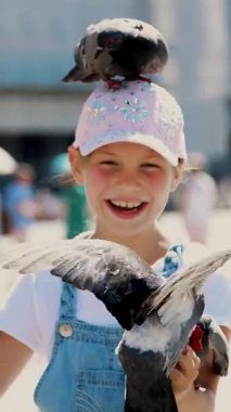 Mutlu kız çocuğu, turist, elinde güvercinler, besleniyor, onlarla oynuyor, San Marco Meydanı 'nda, Aziz Mark Bazilikası' nda eğleniyor.