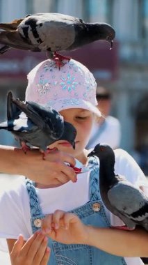 Mutlu kız çocuğu, turist, elinde güvercinler, besleniyor, onlarla oynuyor, San Marco Meydanı 'nda, Aziz Mark Bazilikası' nda eğleniyor.