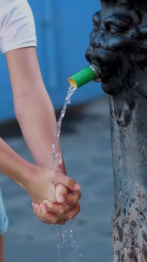 Eski bir Demir Pınar 'dan kristal berrak su akar. Çocuk bir dere altında ellerini yıkar. Kapat.