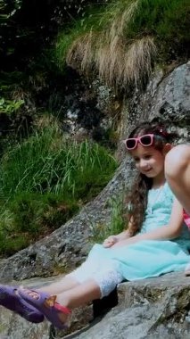 İki güzel kız, çocuklar, kayadaki bir çıkıntıda otururlar, güzel bir turuncu dağ kelebeği döner ve sandaletle bir çocuğun bacağının üzerinden uçar. Kelebek ayağına oturur. Sıcak yaz günü