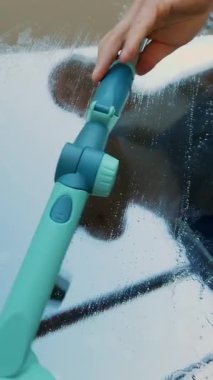 yakın çekim, pencere cam yansıtılır bir adam, Servisi, mavi tulum ve bir kap blaser, temizlik işçisi Temizleme, pencere yıkama tarafından özel paspas,