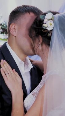 Gelinle damadı öp. Güzel, mutlu, sevecen yeni evliler, gelinlik giyiyorlar, düğünde öpüşüyorlar, sarılıyorlar..