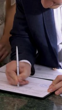 düğün gelenekleri, törenleri. düğün töreni. Yeni evli evlilik belgeleri, evlilik cüzdanı imzalamak. yakın çekim.