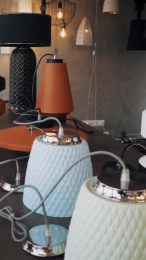 Lambalar ve avizeler dükkanda. İç tasarım için çeşitli aydınlatma araçları. Yarı parçalanmış seramik avizeler, masada lambalar var. Depoda. hafif iç dekorasyon.