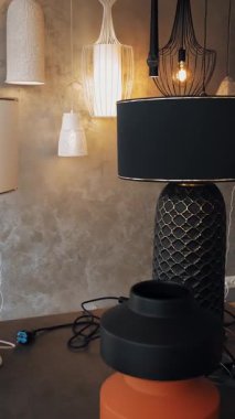 Lambalar ve avizeler dükkanda. İç tasarım için çeşitli aydınlatma araçları. Yarı parçalanmış seramik avizeler, masada lambalar var. Depoda. hafif iç dekorasyon.