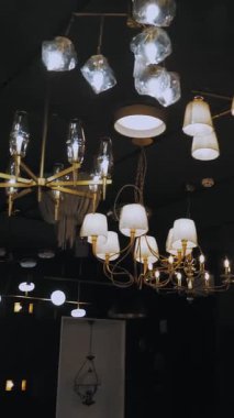 Işıkları kapatıyorum. Dükkanda avizeler. Mağaza vitrininde bir sürü farklı türde lamba ve avize açılıyor. İç tasarım için çeşitli aydınlatma araçları.