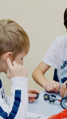 Cherkasy, Ukrayna, 19 Ekim 2019: okul çocukları, oğlanlar ve kızlar, tasarımcıyla oynayın, çeşitli makineler yapın. İş konusunda çok tutkulular.