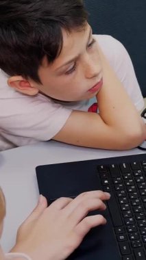 Bilgisayar dersinde dizüstü bilgisayarda çalışan öğrenciler klavyede yazı yazıyorlar. okul ve eğitim