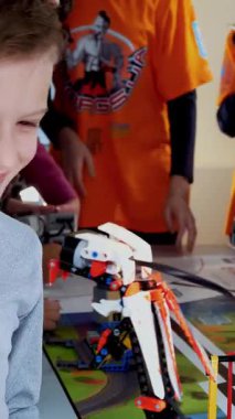 Cherkasy, Ukrayna, 19 Ekim 2019: Çocuk küçük tasarımcılardan oluşan bir robotla oynuyor. Robot hareketleri, bazı hareketleri gerçekleştirebilir. Robotik okulunda eğitim dersi, Kök Eğitim.