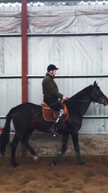 Özel bir hangarda, engelli genç bir adam siyah, safkan bir ata binmeyi öğrenir, hipoterapi. Adamın sağ bacağı yerine yapay bir uzvu var. Hayvanlarla özürlülerin rehabilitasyonu kavramı.