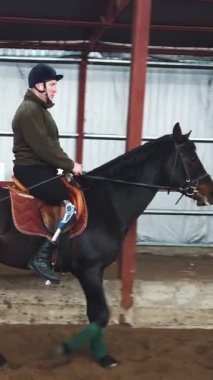 Özel bir hangarda, engelli genç bir adam siyah, safkan bir ata binmeyi öğrenir, hipoterapi. Adamın sağ bacağı yerine yapay bir uzvu var. Hayvanlarla özürlülerin rehabilitasyonu kavramı.