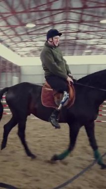 Özel bir hangarda, engelli genç bir adam siyah, safkan bir ata binmeyi öğrenir, hipoterapi. Adamın sağ bacağı yerine yapay bir uzvu var. Hayvanlarla özürlülerin rehabilitasyonu kavramı.