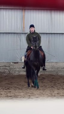 Özel bir hangarda, engelli genç bir adam siyah, safkan bir ata binmeyi öğrenir, hipoterapi. Adamın sağ bacağı yerine yapay bir uzvu var. Hayvanlarla özürlülerin rehabilitasyonu kavramı.