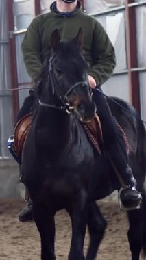 Özel bir hangarda, engelli genç bir adam siyah, safkan bir ata binmeyi öğrenir, hipoterapi. Adamın sağ bacağı yerine yapay bir uzvu var. Hayvanlarla özürlülerin rehabilitasyonu kavramı.